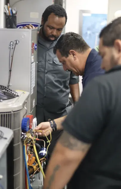 Technicians running diagnostic checks on an air conditioning system