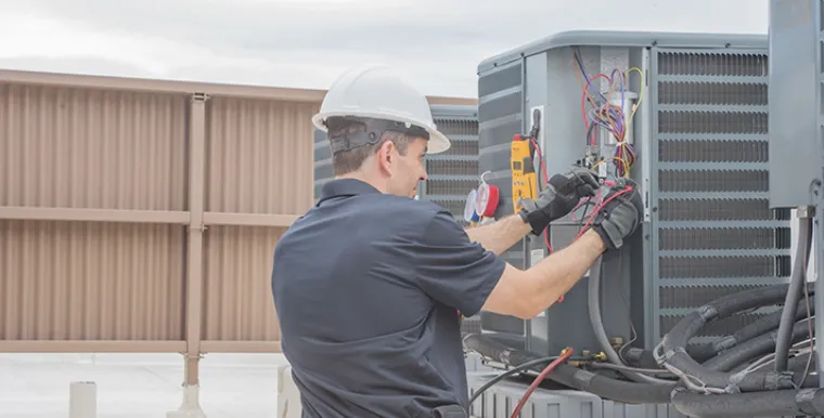 Honest HVAC technician checking an outdoor heat pump unit at a St. Johns home